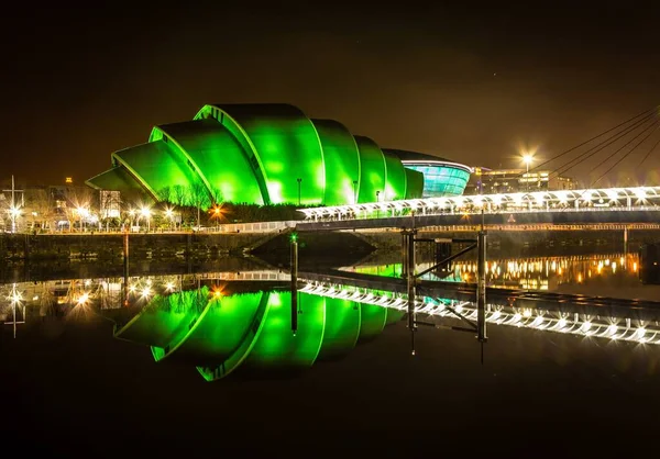 Reflejo de un hermoso edificio con luces verdes en el lago en Glasgow —  Fotos de Stock