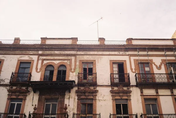 Vue en angle bas d'un ancien bâtiment avec des fenêtres ouvertes sous le ciel clair — Photo