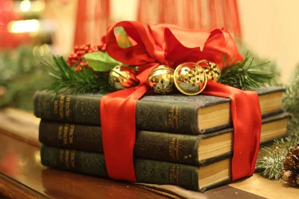 Closeup shot of three old books wrapped in Christmas decoration — Stock Photo, Image