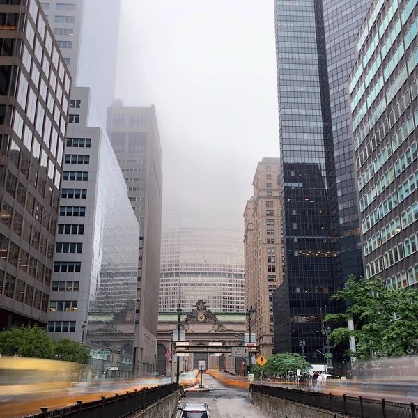 Hermosa foto de rascacielos con ventanas de espejo envueltas en niebla durante el día —  Fotos de Stock