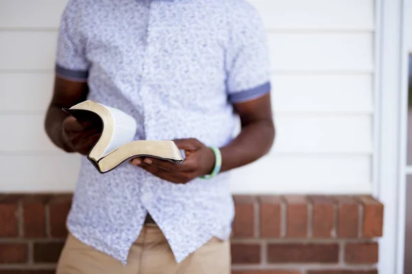 Primer plano de un macho abriendo la Biblia con un fondo borroso — Foto de Stock