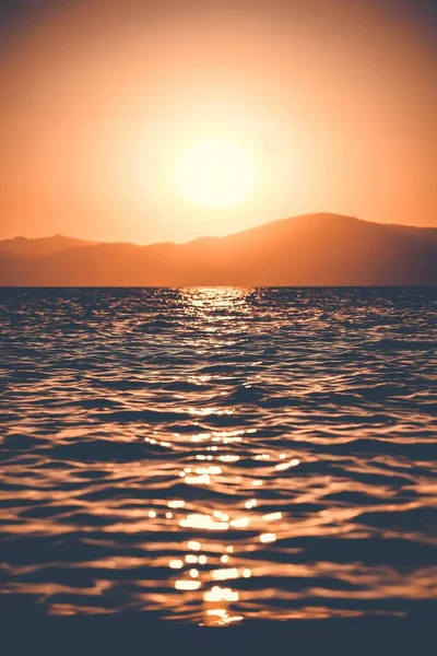 Foto vertical de la impresionante puesta de sol reflejada en el hermoso mar — Foto de Stock