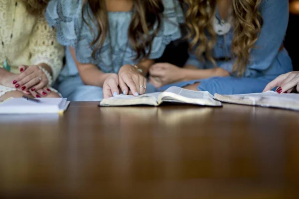 Primer plano de la hembra sentada cerca la una de la otra leyendo la Biblia y tomando notas —  Fotos de Stock