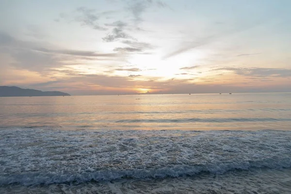 Schöne vertikale Aufnahme des Sonnenuntergangs, die sich im Meer widerspiegelt und eine atemberaubende Landschaft schafft — Stockfoto