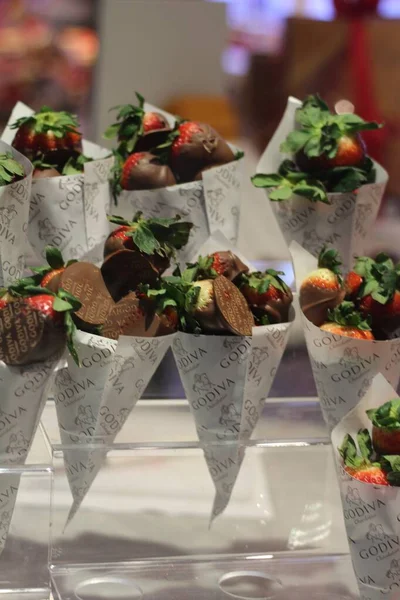 Vertikální záběr na jahody pokryté čokoládou v papírových šiškách pořízené v Las Vegas — Stock fotografie