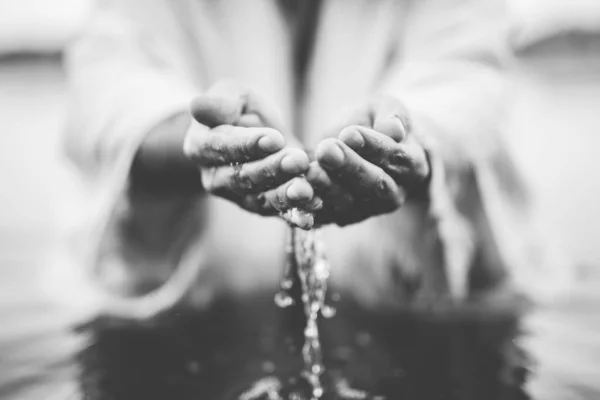 Closeup tiro de uma pessoa bebendo água com as mãos em preto e branco — Fotografia de Stock