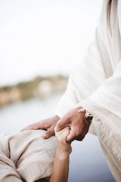 Vertikální záběr Ježíše Krista, jak uzdravuje ženu s rozmazaným pozadím — Stock fotografie