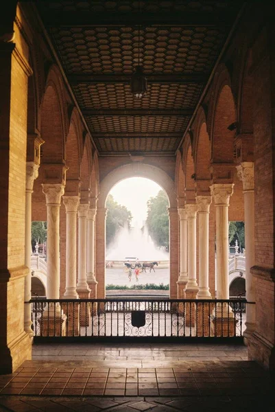 Vertical shot of concrete arches with a beautiful fountain in the background — Stock Photo, Image