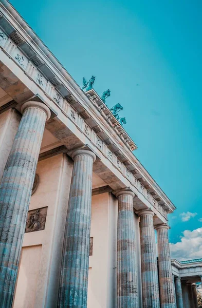 Fotografía vertical de bajo ángulo de la Puerta de Brandeburgo en Berlín bajo el brillante cielo puro — Foto de Stock