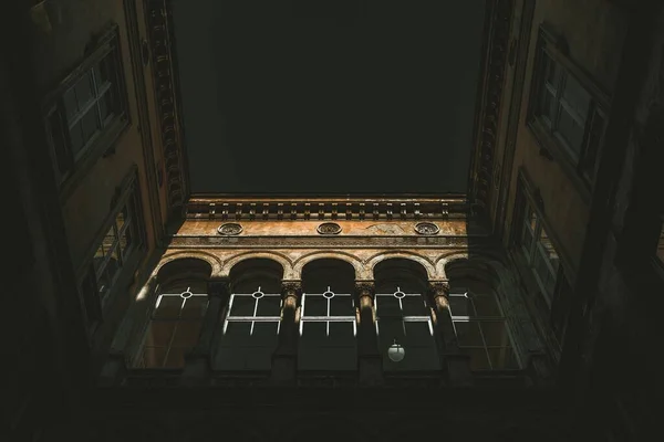 Vista de bajo ángulo de un antiguo edificio con giros arquitectónicos bajo el cielo oscuro de Europa — Foto de Stock