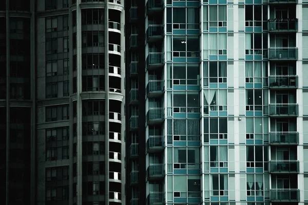 Skott av en byggnad med glasfönster och vita gardiner — Stockfoto