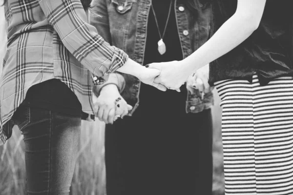 Closeup shot of females holding hands and praying in black and white — Stock Photo, Image