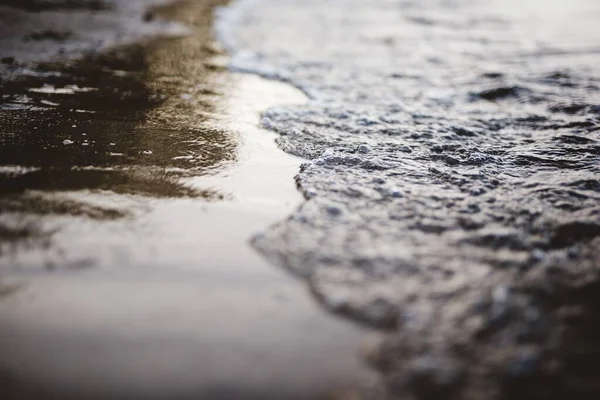 Gros plan des vagues de mer qui arrivent sur le rivage avec un arrière-plan flou — Photo