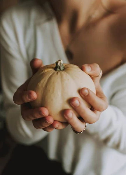 Enfoque selectivo vertical de una hembra sosteniendo una calabaza — Foto de Stock