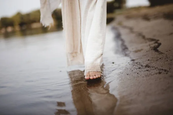 Närbild bild av en kvinna bär en biblisk mantel promenader på stranden med suddig bakgrund — Stockfoto