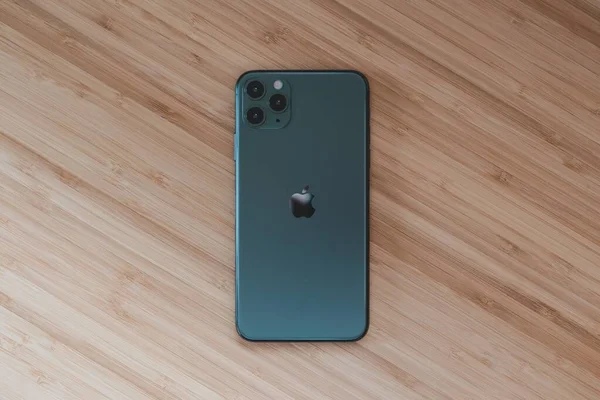 High angle shot of a phone in a black case on a wooden surface — Stock Photo, Image