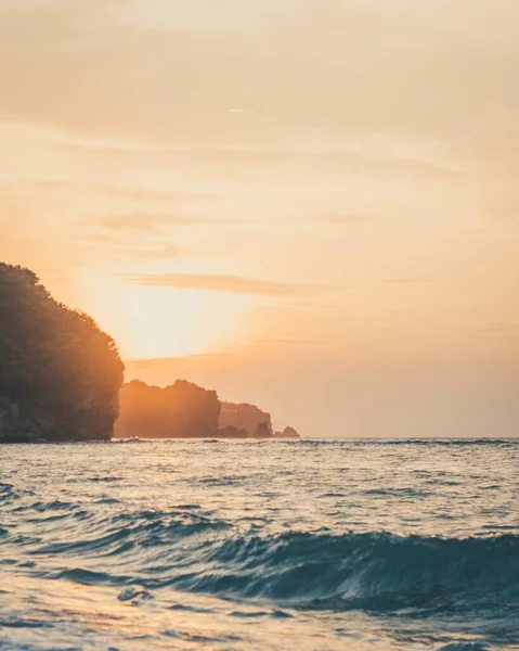 背景是太阳落山的波浪形海洋的垂直摄影 — 图库照片