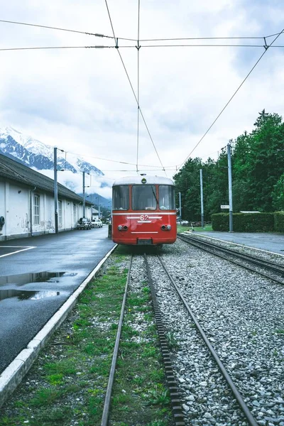 Vertikální záběr červené tramvaje pohybující se přes koleje — Stock fotografie