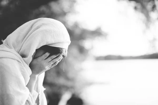 Close-up tiro de uma fêmea vestindo um manto bíblico e chorando em preto e branco — Fotografia de Stock