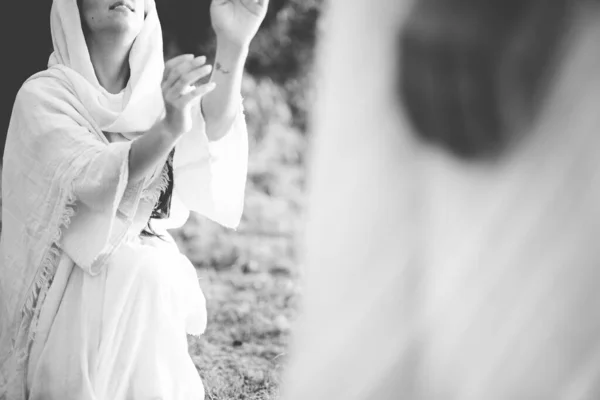 Scène biblique d'une femme vêtue d'une robe biblique qui lève les mains vers Jésus-Christ — Photo