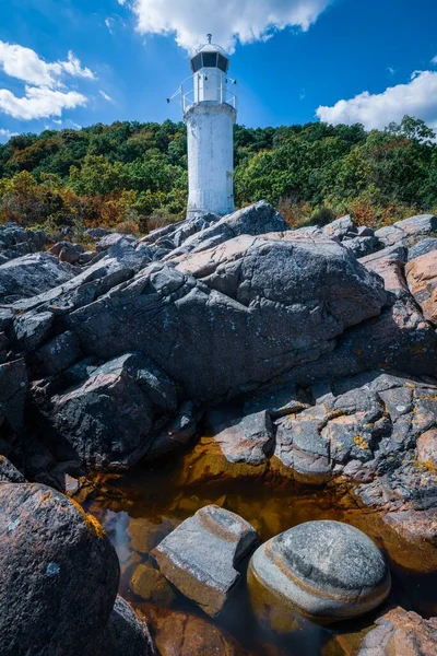 Vue Verticale Phare Entouré Rochers Verdure Sous Lumière Soleil Ciel — Photo