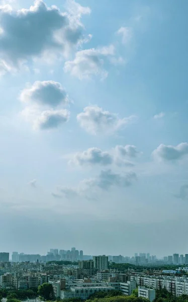 日の出には雲がふわふわの青空の下の街並みの垂直空撮 — ストック写真