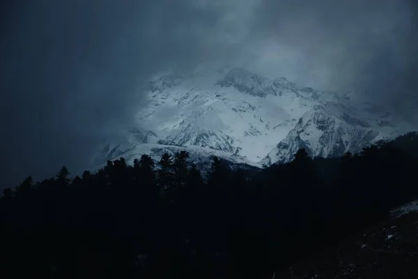 Picos Nevados Das Montanhas Cobertas Pelas Nuvens Cinzentas Escuras — Fotografia de Stock