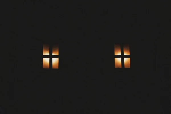 Karanlığın Içindeki Bir Binanın Dış Tarafındaki Iki Pencerenin Yakın Çekimi — Stok fotoğraf
