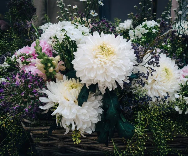 特写照片 里面有奇异的白色和紫色的花朵 还有篮子里的小雏菊 — 图库照片