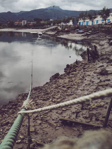 어두운 배들이 항구의 사격이 배경의 산들과 — 스톡 사진