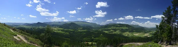 緑の山々と青空のパノラマのショット — ストック写真