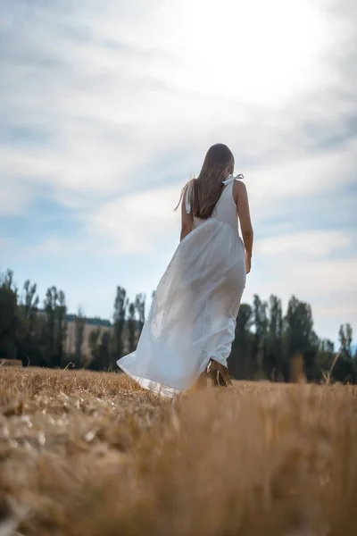 在干枯的稻草地里拍到一个穿着白衣的年轻漂亮的农妇 — 图库照片