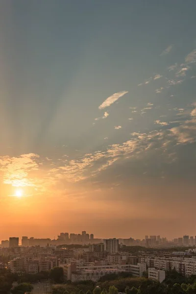 夕暮れ時のオレンジ色の空の下の街並みの垂直空撮 — ストック写真