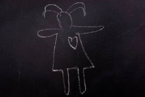 黒い板の上にチョークで描かれた耳を持つ少女のシルエットのクローズアップショット — ストック写真