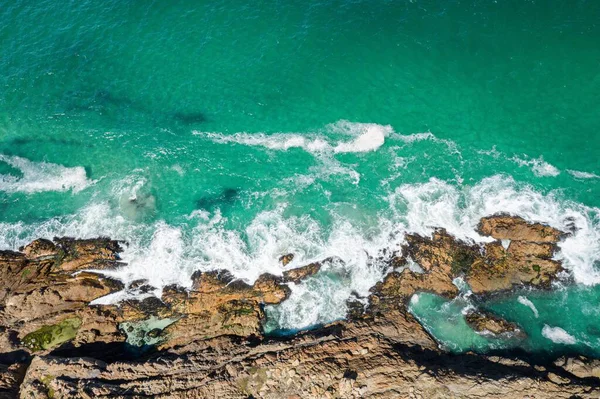 昼間は純粋なターコイズブルーの水と崖のある海岸のオーバーヘッドショット — ストック写真