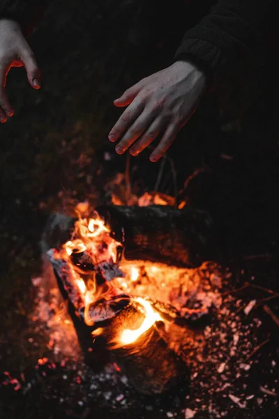 Высокоугольный Снимок Человека Согревающего Руки Костра Ночью — стоковое фото