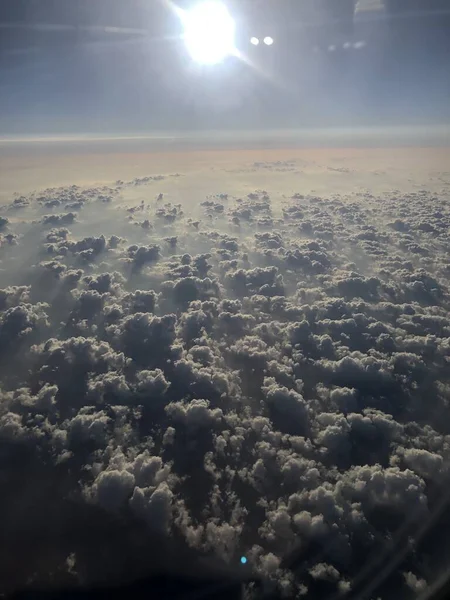 空の雲の上に輝く太陽の垂直ショット — ストック写真