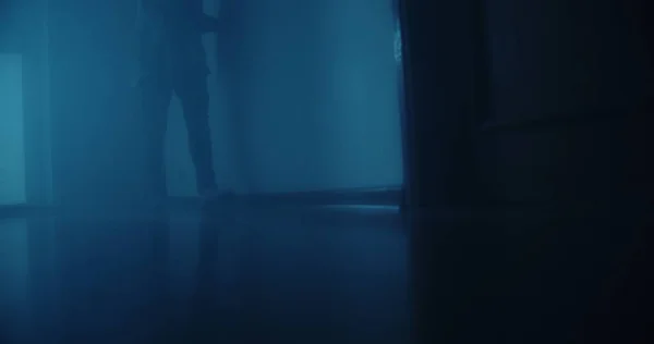 廊下から青い光が差し込む部屋を歩く孤独な男 — ストック写真