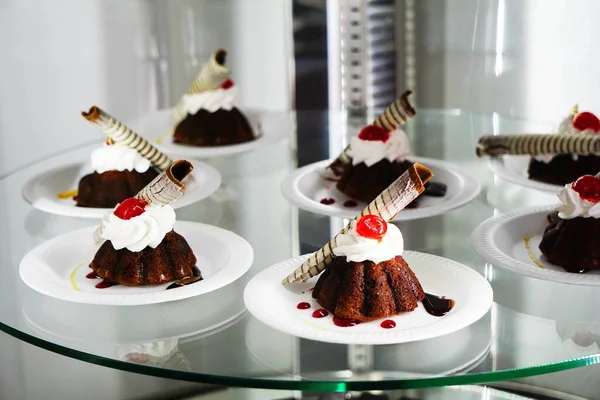 Μια Επιλεκτική Λήψη Cupcakes Λευκά Πιάτα Ένα Γυάλινο Τραπέζι — Φωτογραφία Αρχείου