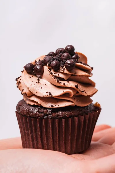 Colpo Verticale Una Persona Che Tiene Cupcake Cioccolato Sotto Luci — Foto Stock