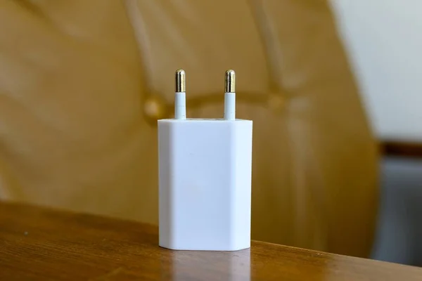 木桌上一个白色充电器插头的特写镜头 — 图库照片