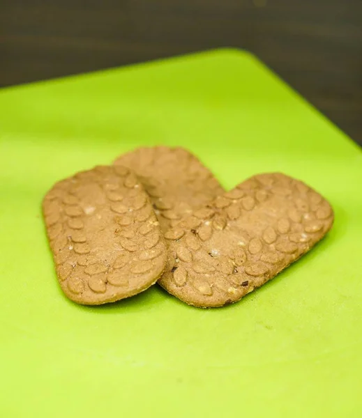 緑のボード上の3つの新鮮な穀物クッキーのクローズアップショット — ストック写真