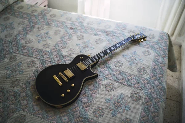 Plan Grand Angle Une Guitare Électrique Noire Sur Lit Avec — Photo