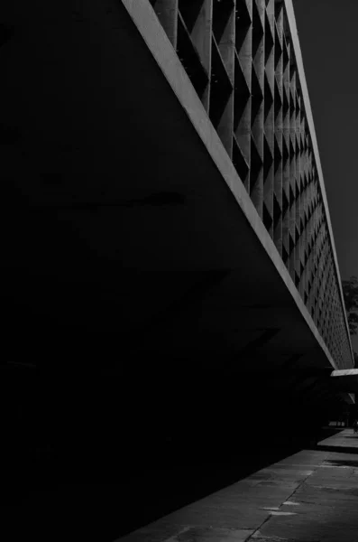 Eine Vertikale Graustufenaufnahme Eines Modernen Gebäudes Unter Bewölktem Himmel — Stockfoto