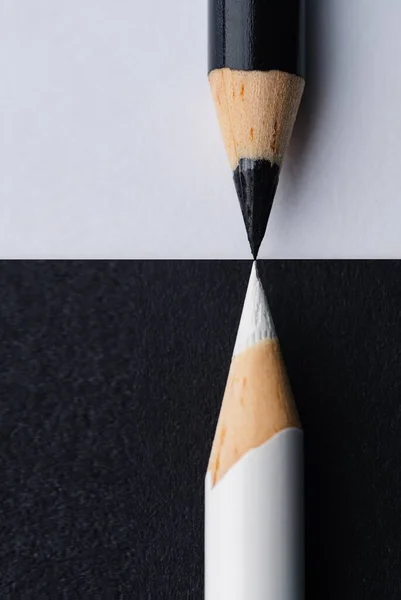 在黑白背景上的黑白铅笔的特写垂直截图 与之形成对比的完美连接概念 — 图库照片