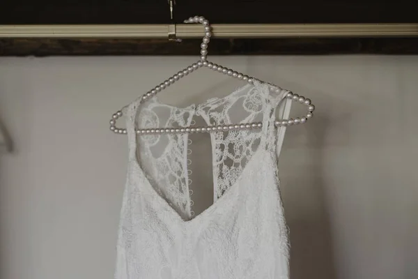 ハンガーから吊るされた白いブライダルドレスのショット — ストック写真