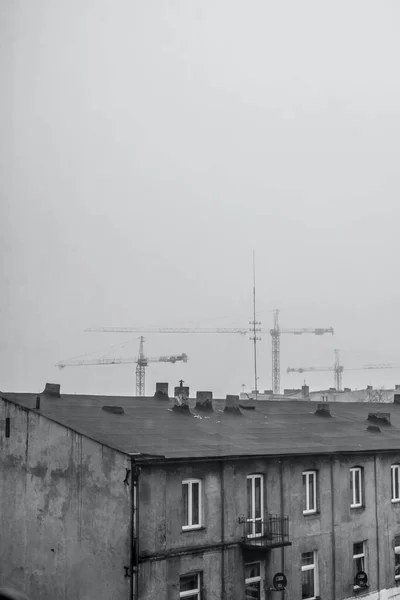 Вертикальний Сірий Знімок Старого Даху Будівлі Фоні Баштових Кранів — стокове фото