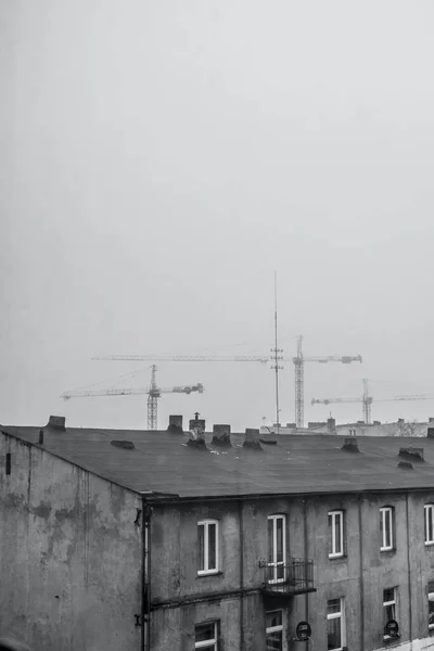 Vertical Grayscale Shot Old Building Roof Tower Cranes Background — Stock Photo, Image