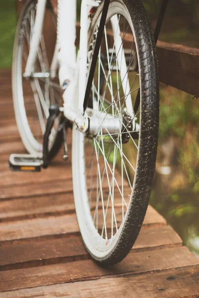 Disparo Vertical Cierre Las Ruedas Una Bicicleta Estacionada Puente Madera —  Fotos de Stock