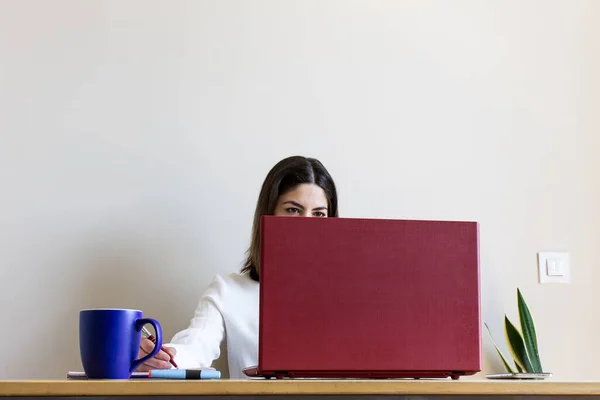 由于科维德19号的检疫 一名年轻女性坐在家里 带着笔记本电脑和一杯咖啡工作 — 图库照片